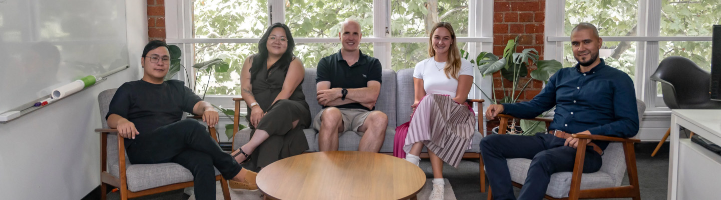 A group shot of sonar group consultants sitting on a sofa