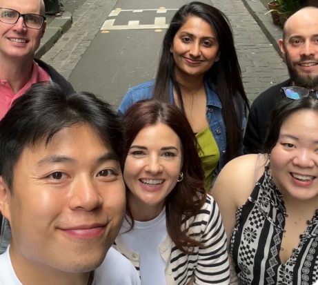 A group of selfie of sonar employees walking down an alley way after a team lunch